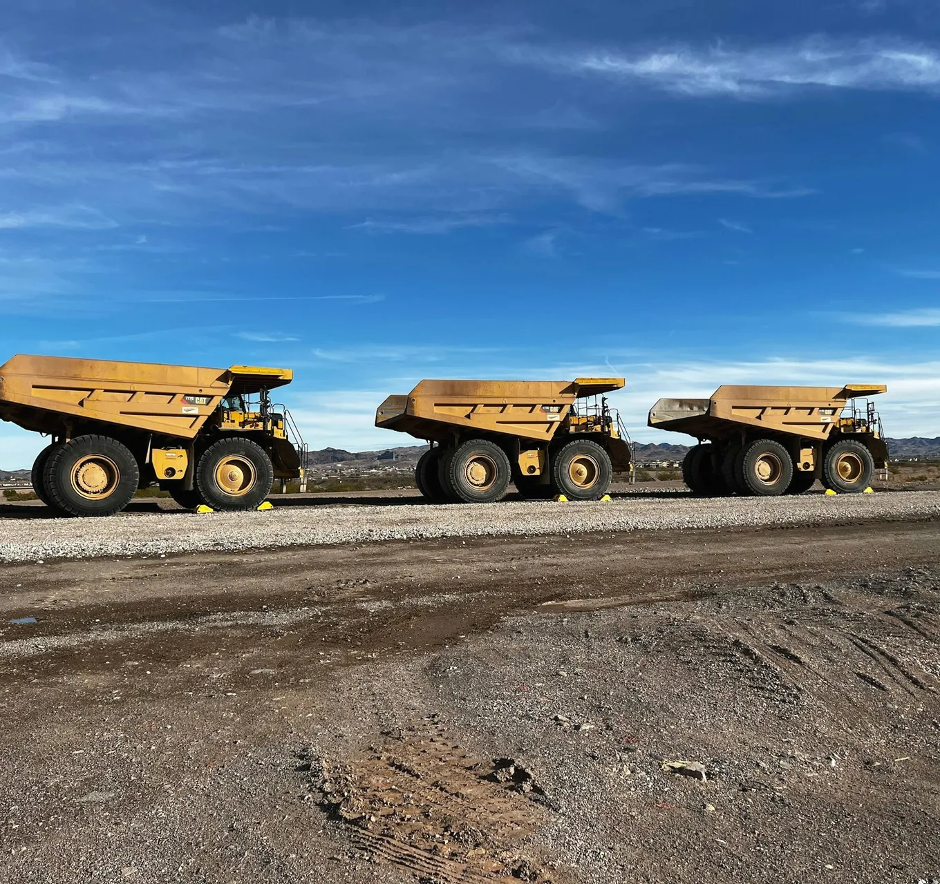 Haul trucks lined up on a mine haul road