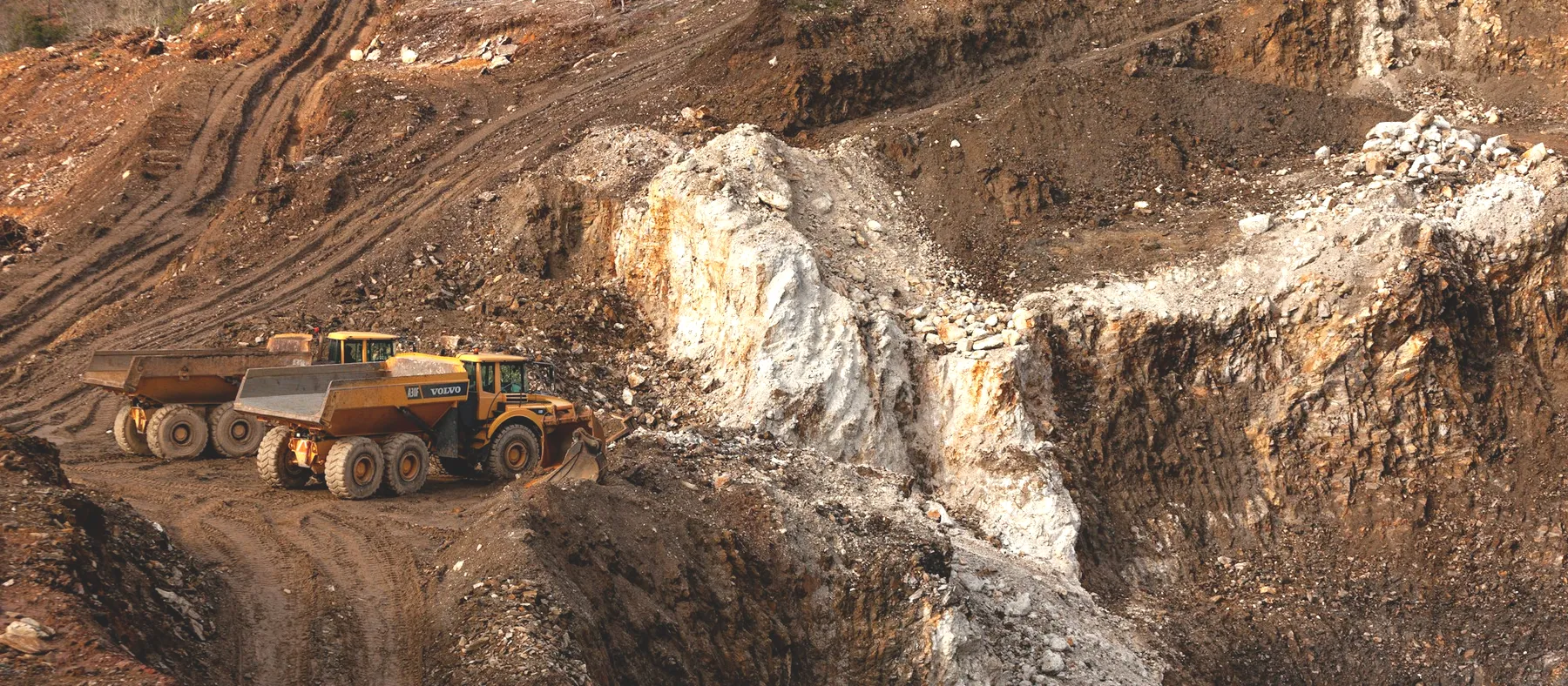 A haul truck working a pit surrounded by open country